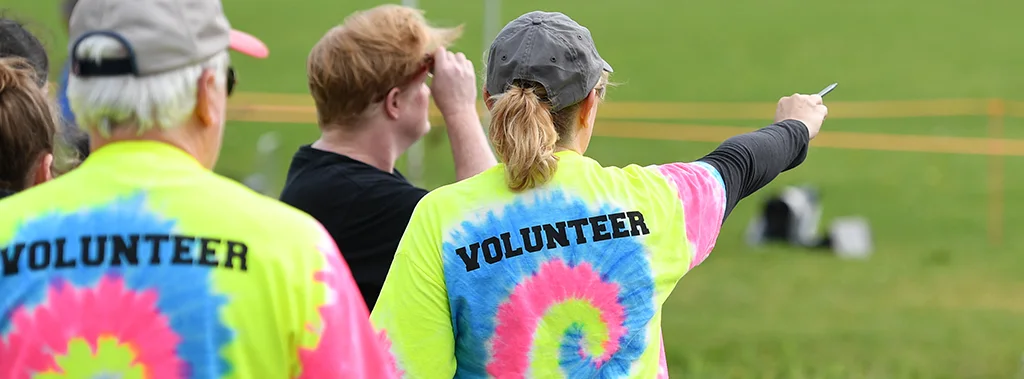 a group of volunteers in a field wearing YMCA volunteer t-shirts