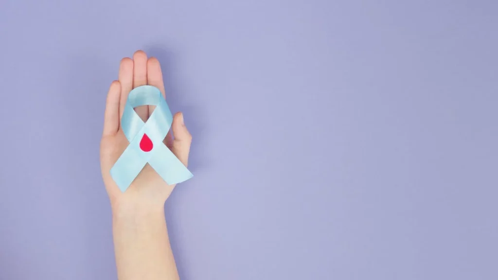 person holding a blue diabetes awareness ribbon in the palm of their hand