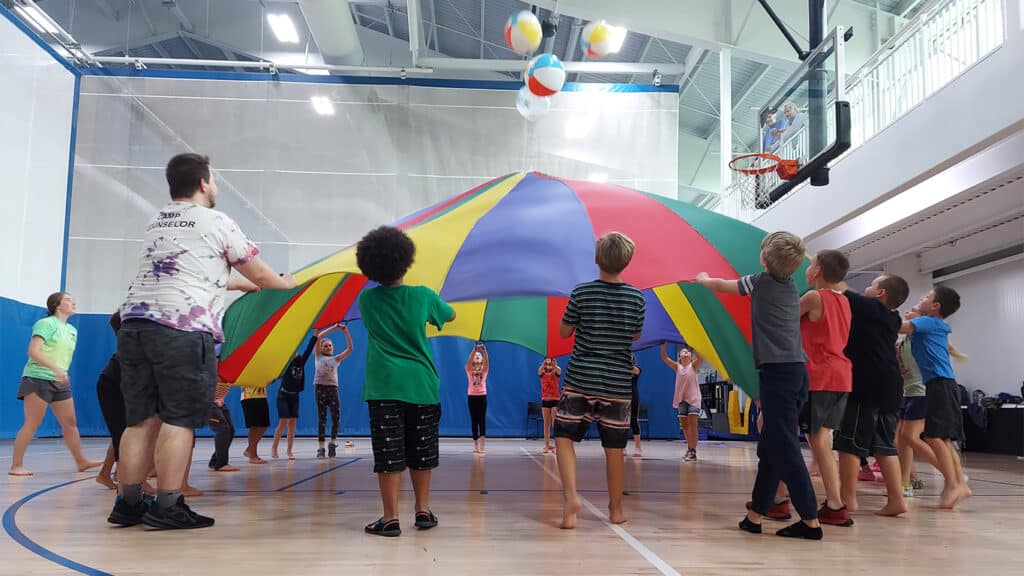 kids playing with a ball and a parachute
