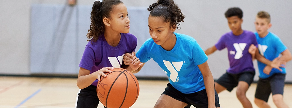 Adult and Youth Sports two girls playing basketball at the keene family YMCA