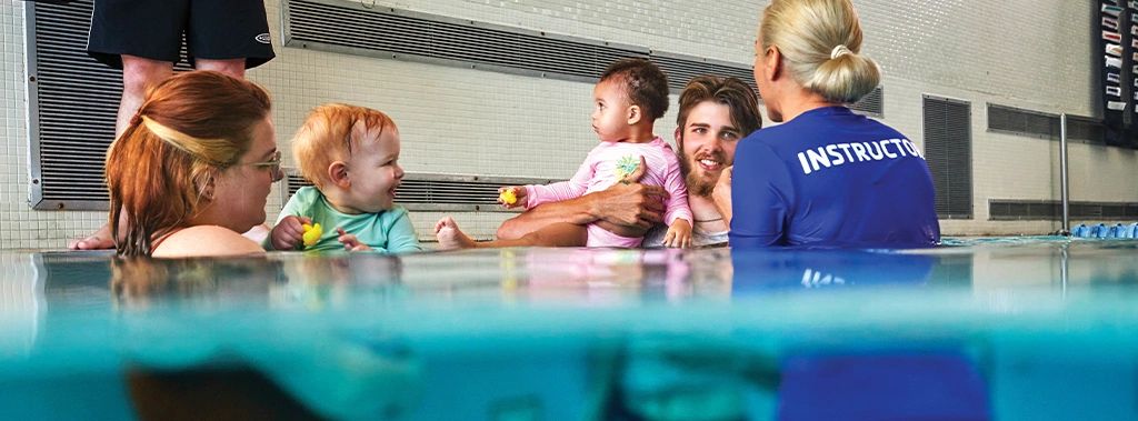 teacher showing parents and children how to swim during class