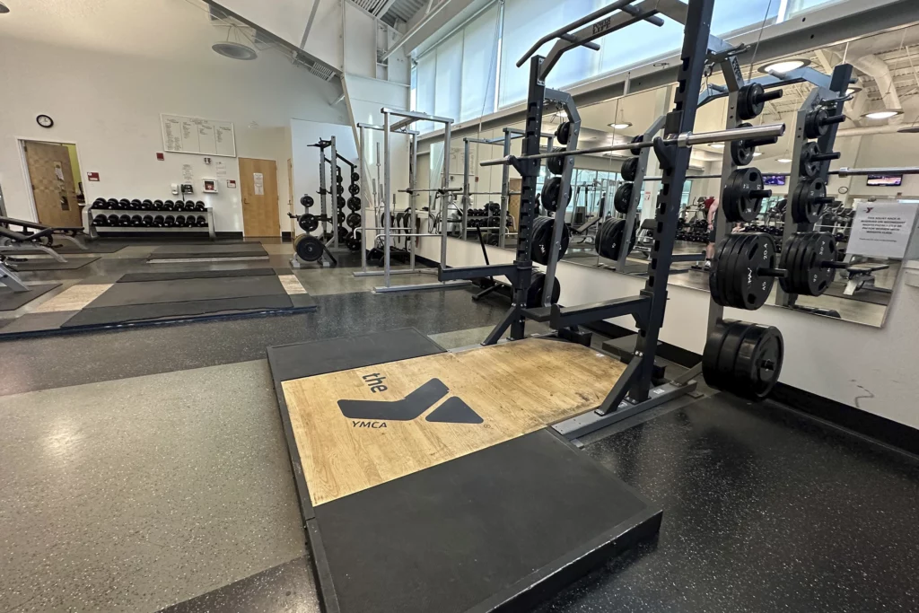 the keene YMCA's weight room showing weights, mirrors, and deadlifting equipment